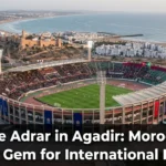 Stade Adrar in Agadir, Morocco, a modern 45,000-seat football stadium on the Atlantic coast, hosting international matches and major tournaments against the backdrop of the Atlas Mountains.