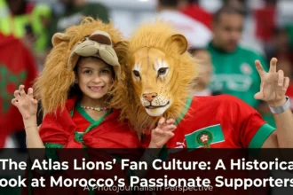 Passionate Morocco national team supporters waving flags, singing chants, and filling stadium stands with red and green colors during an Atlas Lions match.