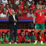 Morocco national team midfielders controlling possession, distributing passes, and driving play during an international football match, showcasing the engine room of the Atlas Lions.
