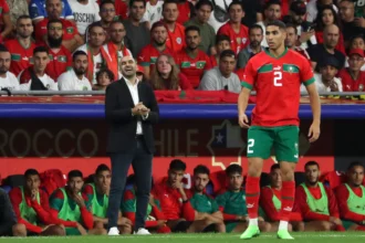Morocco national team midfielders controlling possession, distributing passes, and driving play during an international football match, showcasing the engine room of the Atlas Lions.
