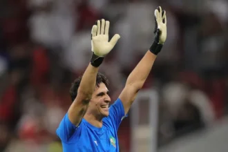 Morocco national team goalkeepers making crucial saves and organizing the defense during an international football match, highlighting their importance as the team's last line of defense.