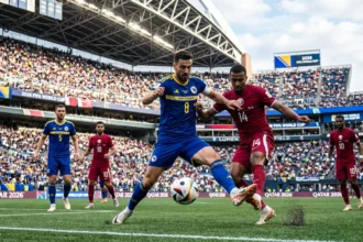 Bosnia-Herzegovina and Qatar players battle for the ball during their Group B match at Lumen Field in the 2026 FIFA World Cup.